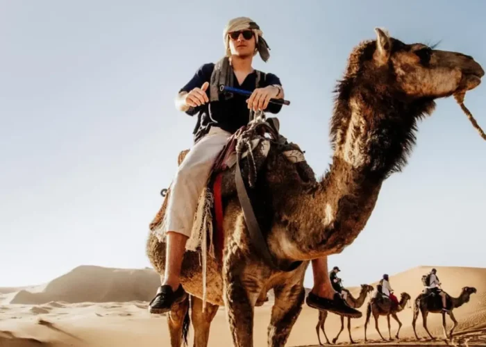 Viaggiatori in cammello tra le dune di Merzouga durante il Tour deserto Marocco 2 giorni da Fes a Marrakech