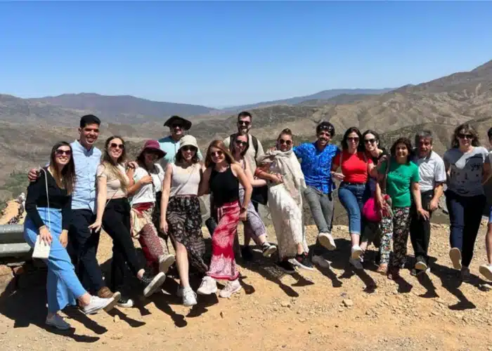 Viaggiatori con abiti berberi che ammirano il paesaggio delle montagne dell’Alto Atlante durante il tour 3 giorni da Marrakech verso il deserto di Merzouga.