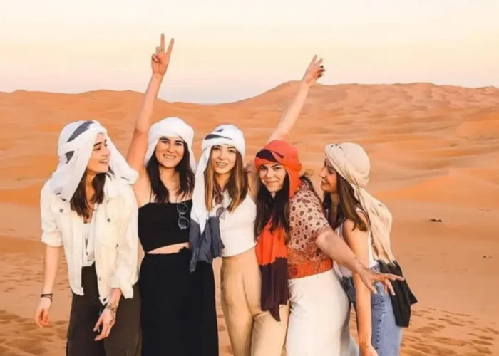 Gruppo di clienti durante il tour deserto da Casablanca 5 giorni mentre fanno un’escursione in cammello tra le dune del Sahara al tramonto