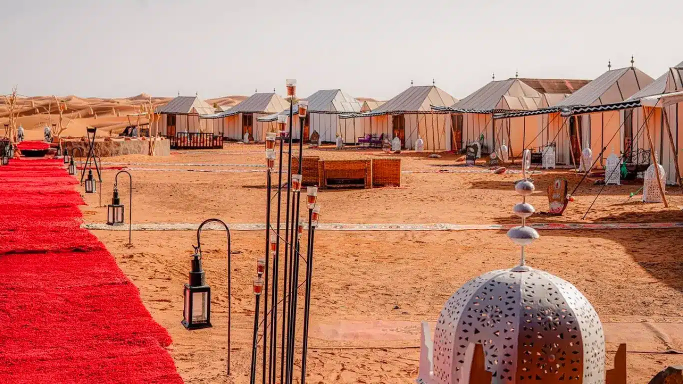 Tour di 4 Giorni in Marocco – Campo tendato di lusso al tramonto nel Sahara Campo tendato di lusso nel deserto di Merzouga al tramonto durante un tour di 4 giorni in Marocco da Fes a Marrakech